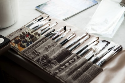Various paint rollers and brushes arranged neatly on a wooden table