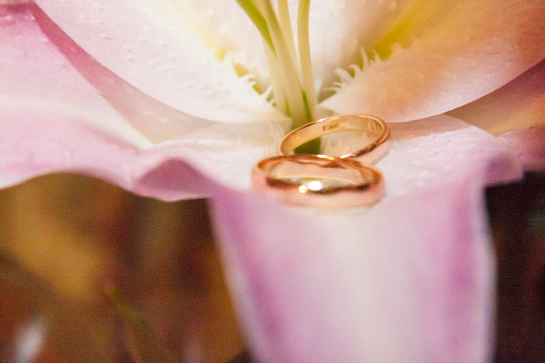 gold wedding band on white flower