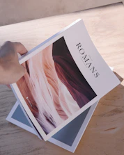 person holding white and black labeled book