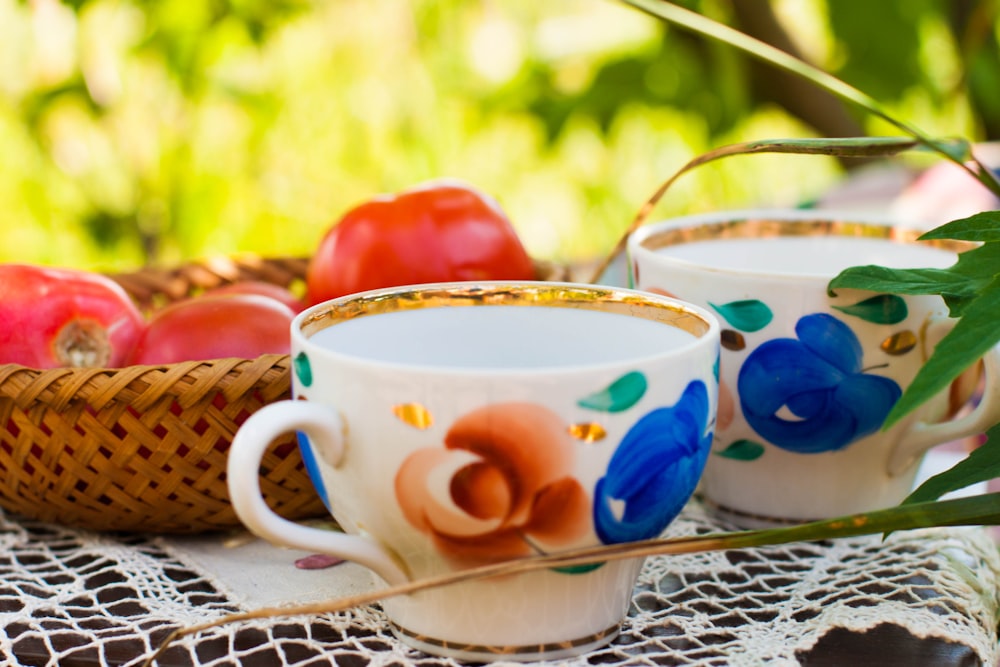 weißblaue und rote florale Keramik-Teetasse auf weißer und blauer Keramikuntertasse