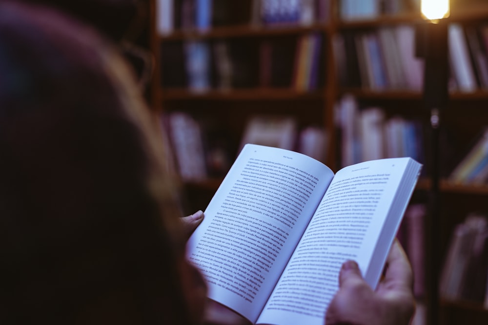 person reading book in library