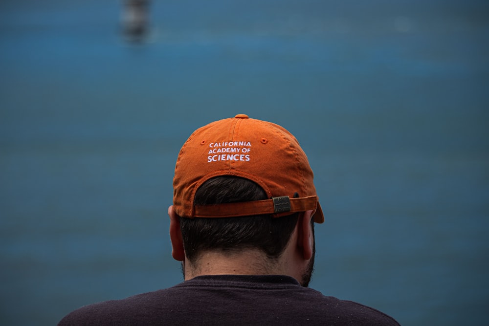 man in orange and white cap and black shirt