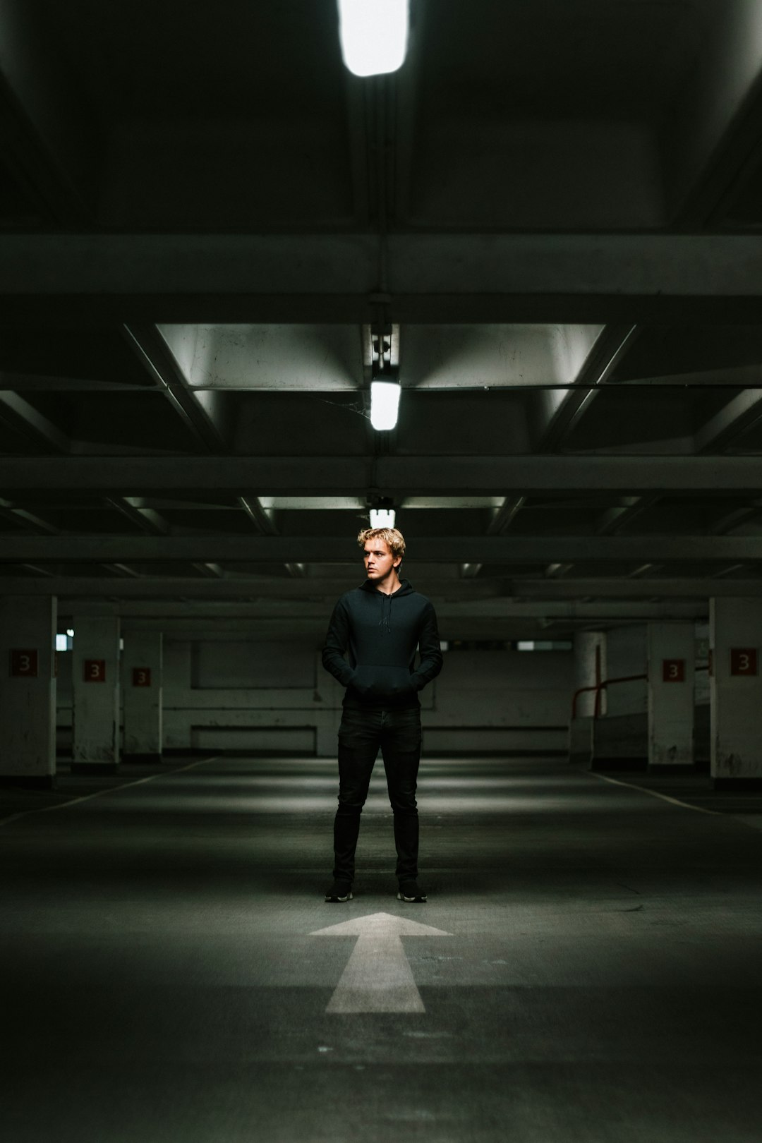man in black jacket standing on gray floor