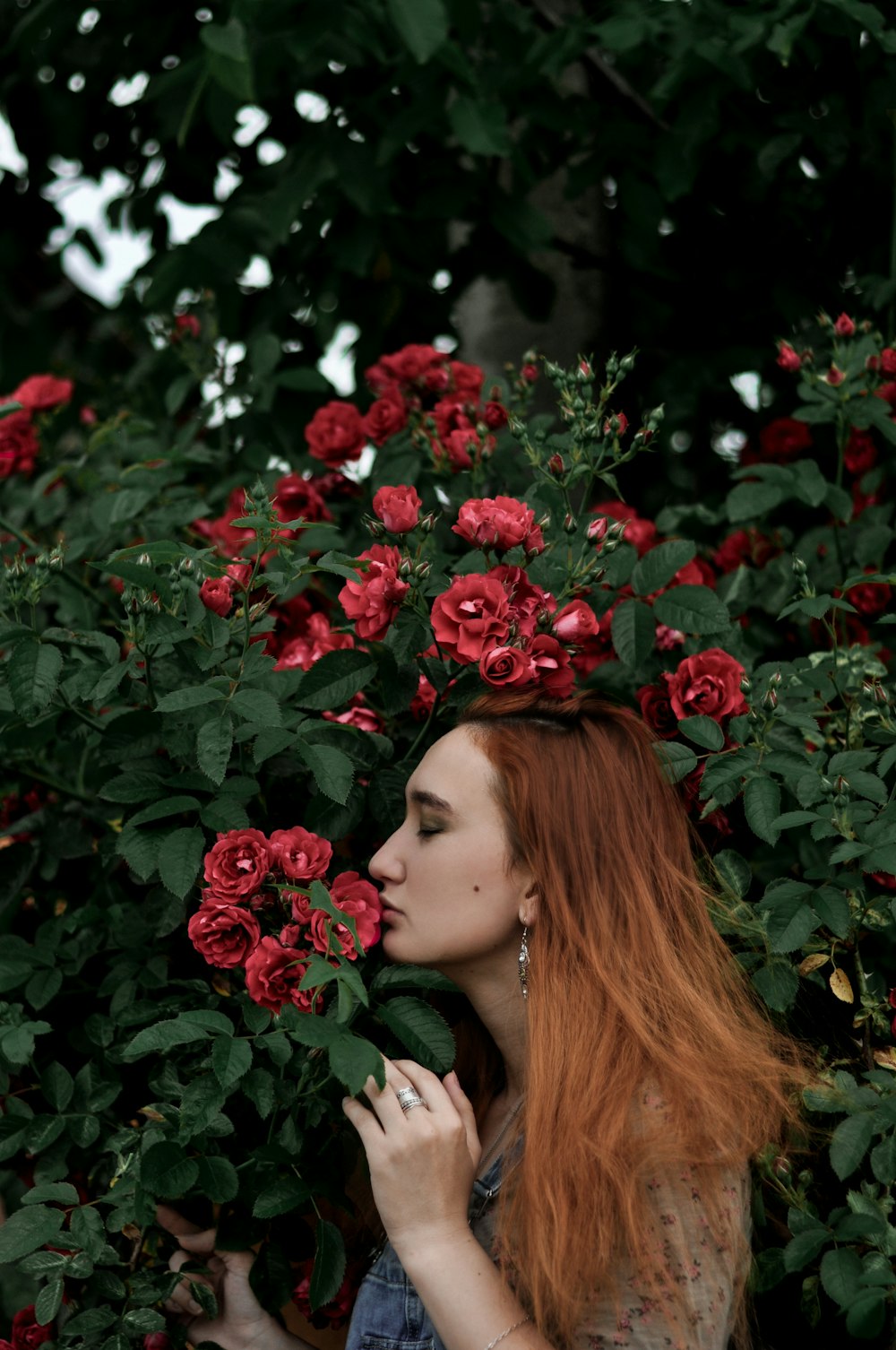 woman in red lipstick surrounded by red flowers