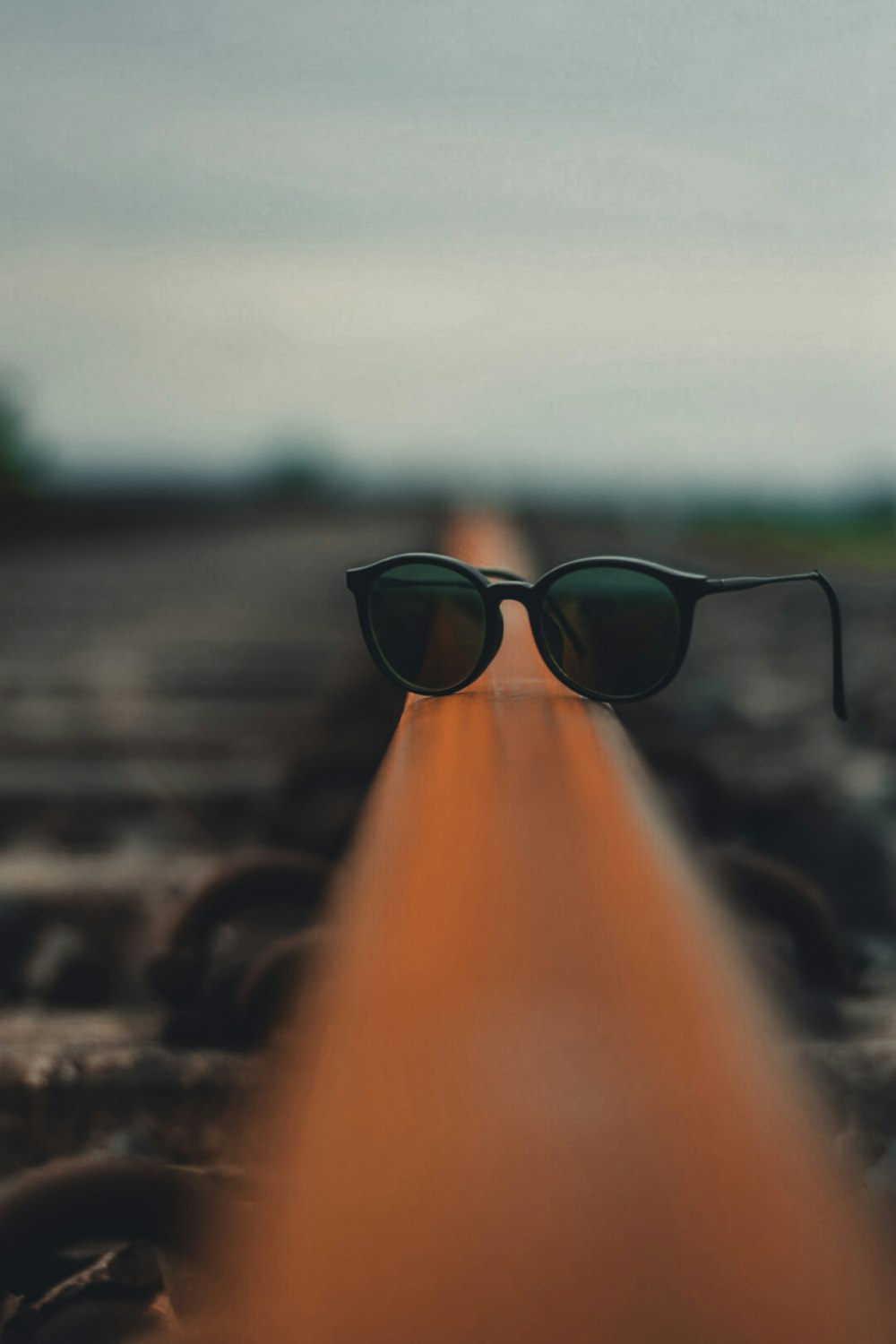 black framed sunglasses on orange metal bar during daytime