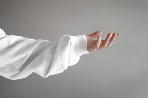 A calm pastel-colored illustration of hands signing a friendly greeting.