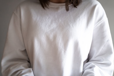 Model wearing a relaxed-fit unisex sweatshirt in muted tones, styled simply