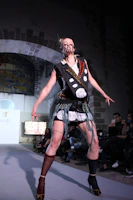 A runway model showcasing a bold, colorful outfit under bright lights.