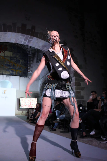 A dramatic, avant-garde fashion piece inspired by tarot cards, displayed in a dark, high-contrast setting.