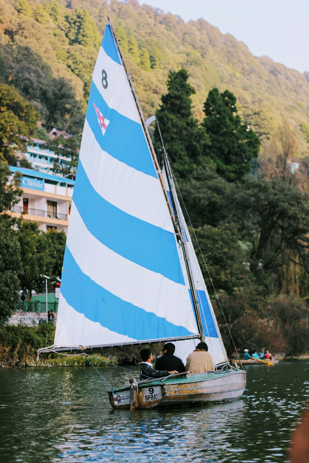 white and blue sail boat on body of water during daytime