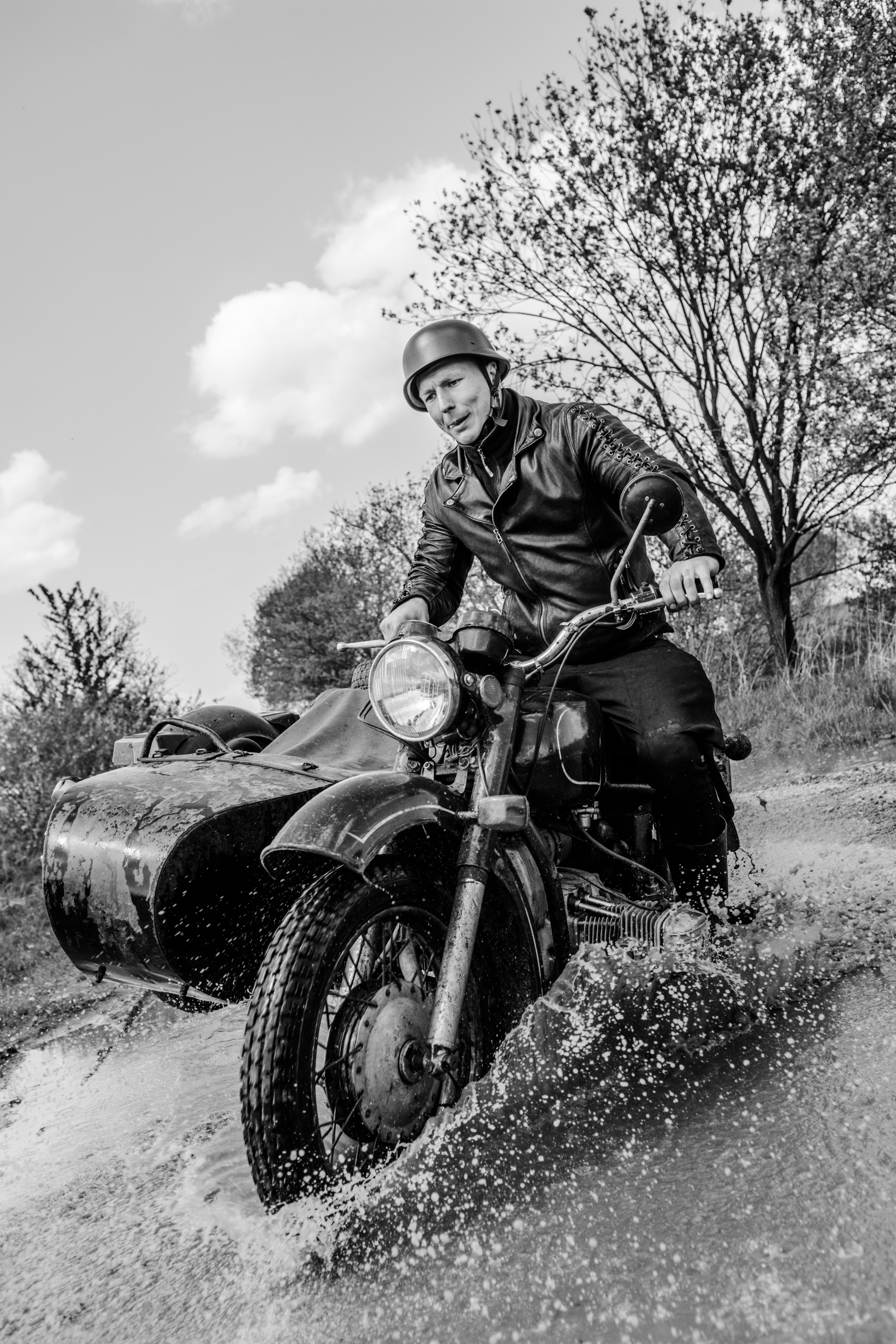 grayscale photo of man riding motorcycle