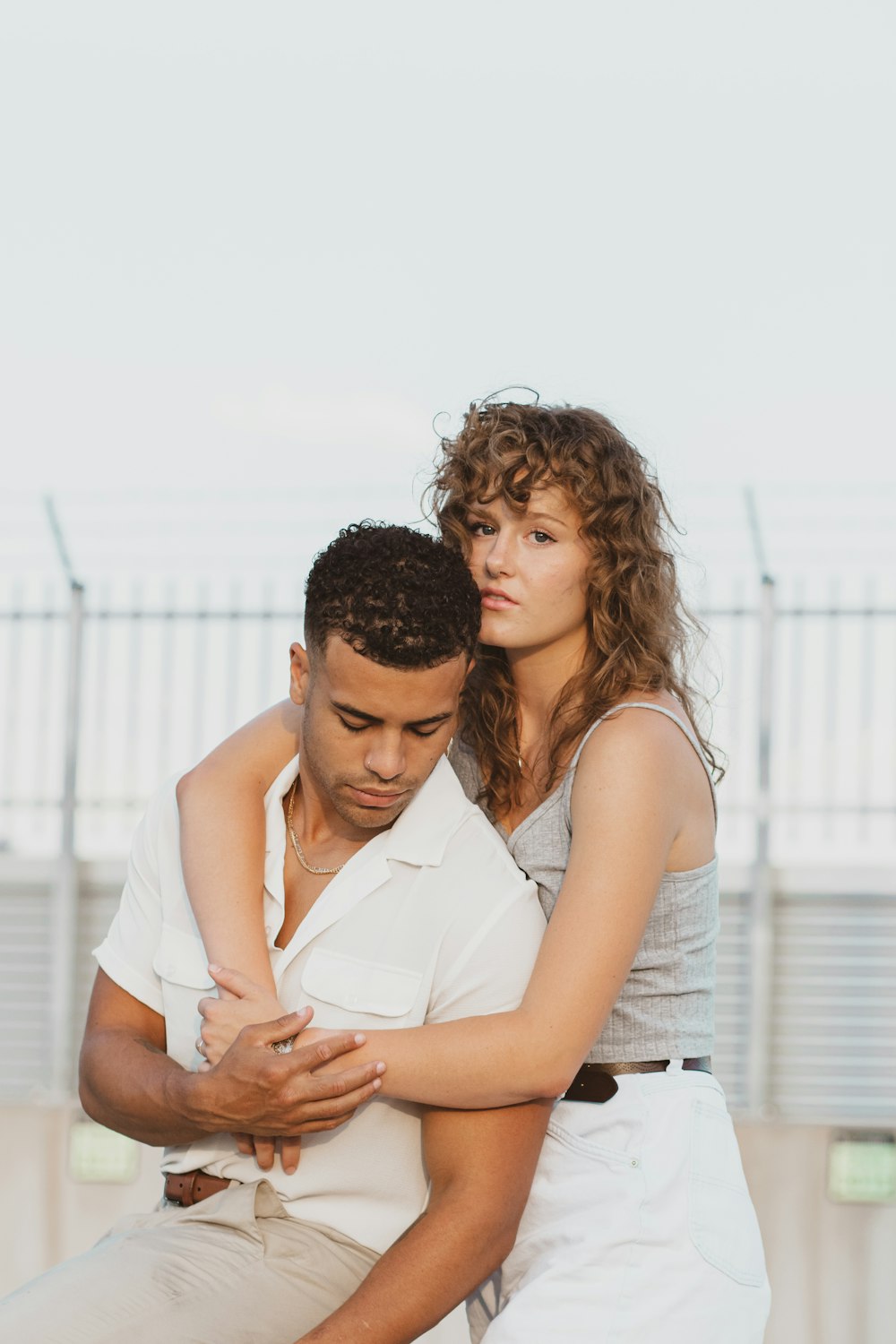 man in white button up shirt kissing woman in white sleeveless shirt