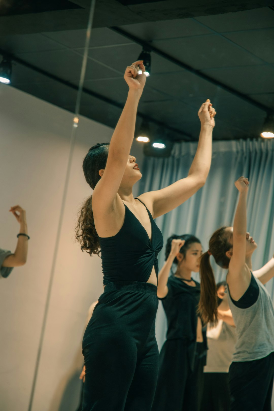 woman in black tank top raising her hands