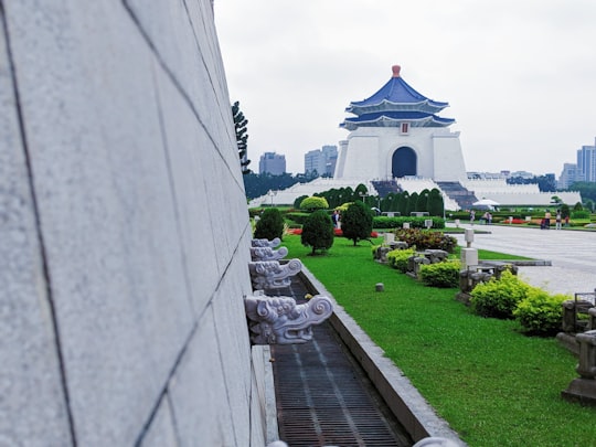 green grass field near white concrete building during daytime in National Chiang Kai-shek Memorial Hall Taiwan