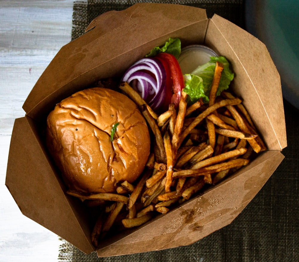 hamburguesa y papas fritas en bolsa de papel marrón