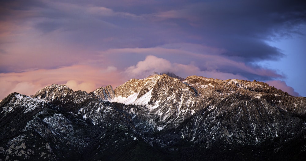 snow covered mountain under cloudy sky during daytime