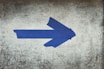 blue arrow sign on gray textile