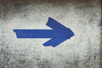 blue arrow sign on gray textile