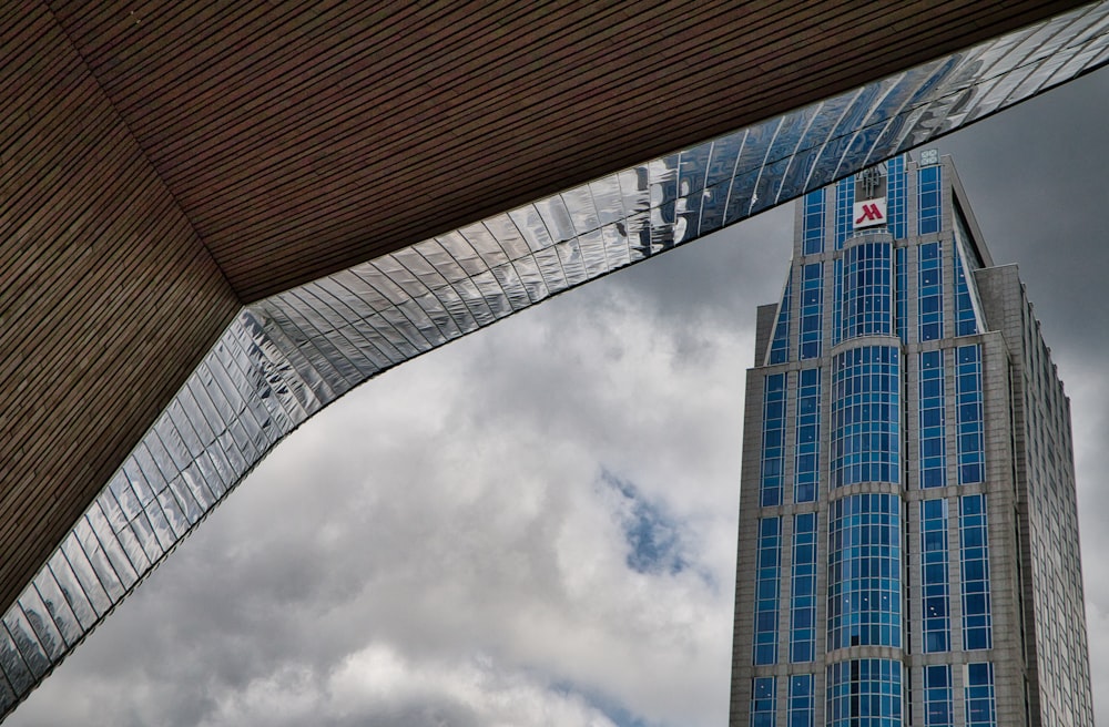 blue and white high rise building under white clouds during daytime