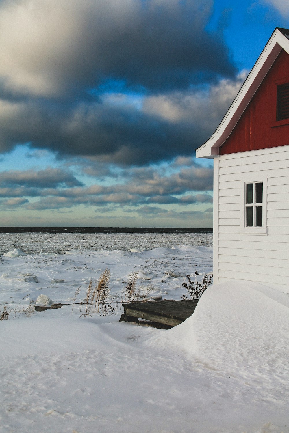 a red and white house sitting on top of snow covered ground