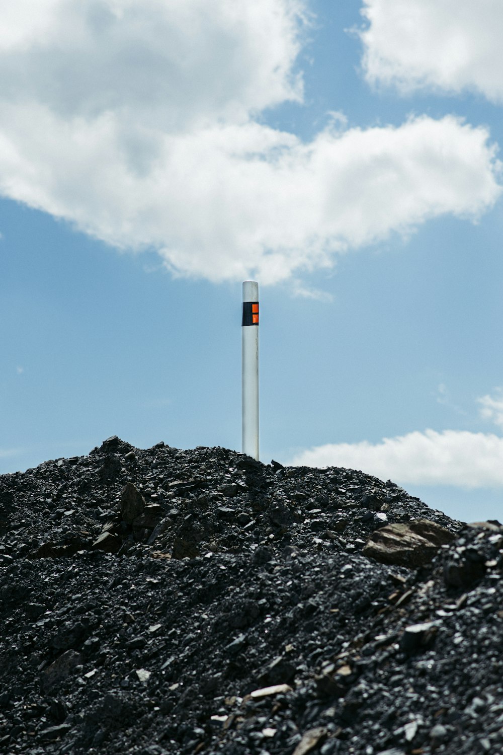 weiß-roter Turm auf felsigem Boden unter blauem Himmel tagsüber