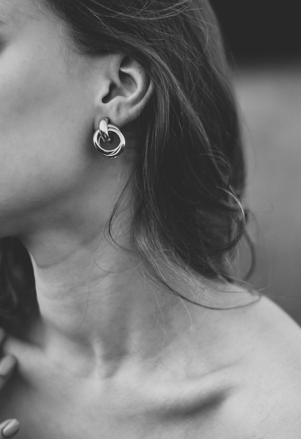 grayscale photo of woman wearing silver stud earring