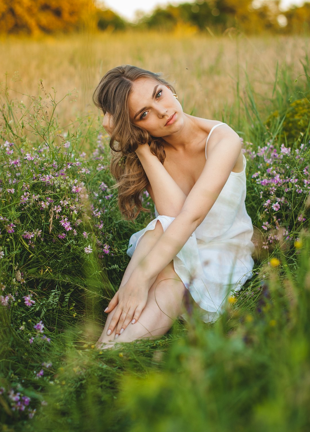 woman in white dress sitting on green grass field