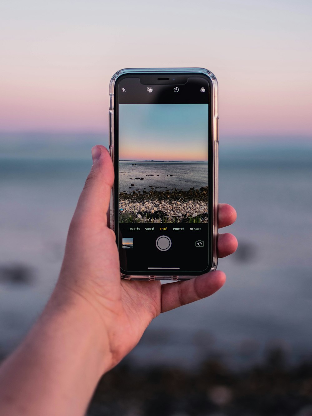 person taking photo of body of water during daytime