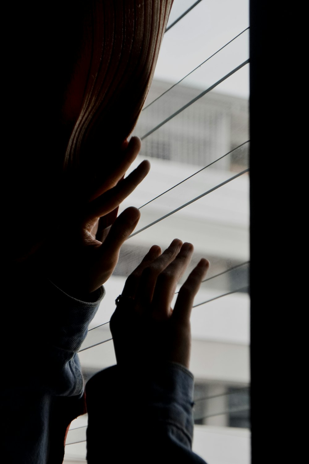 woman in gray long sleeve shirt covering her face