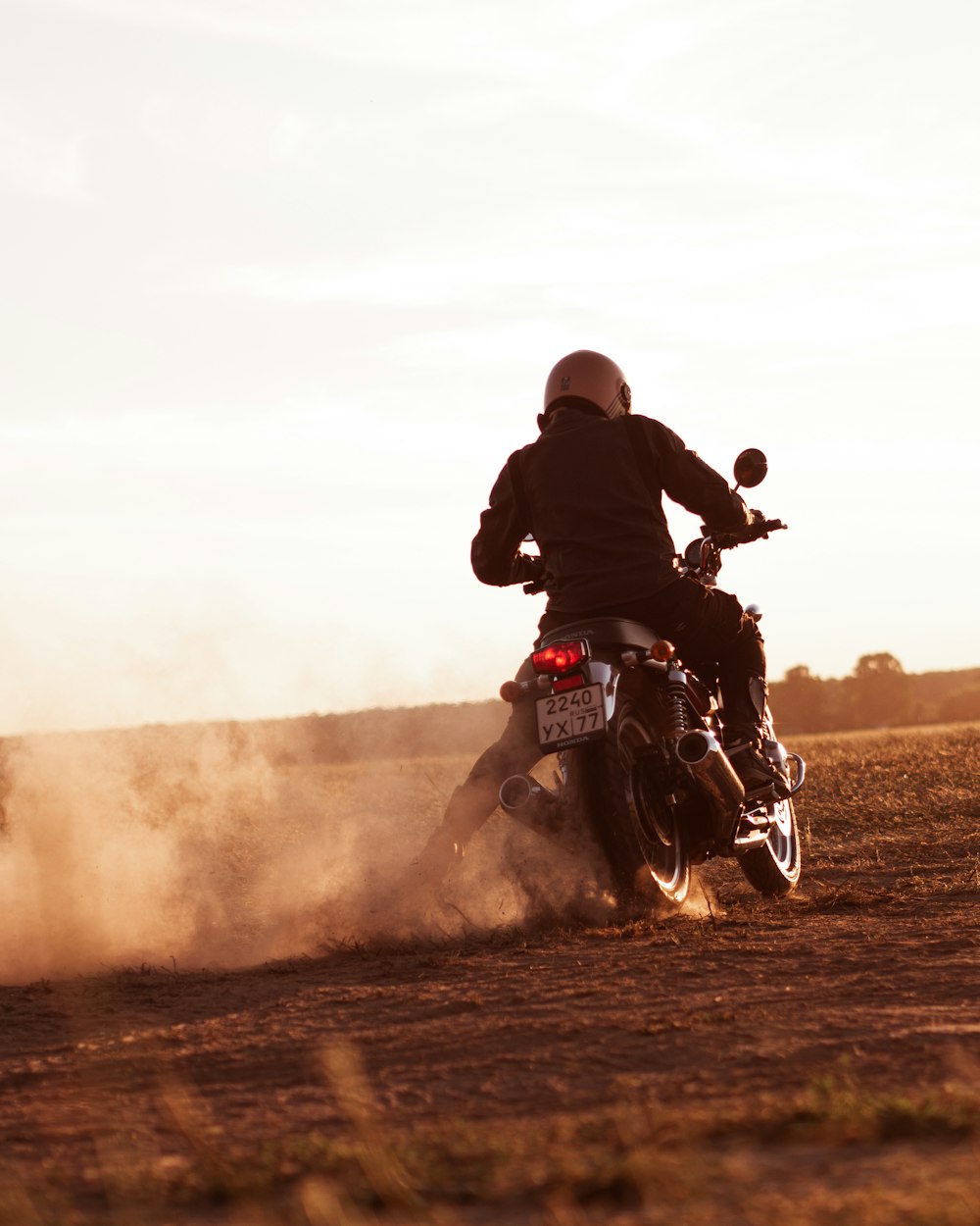 man riding on red and white dirt motorcycle during daytime