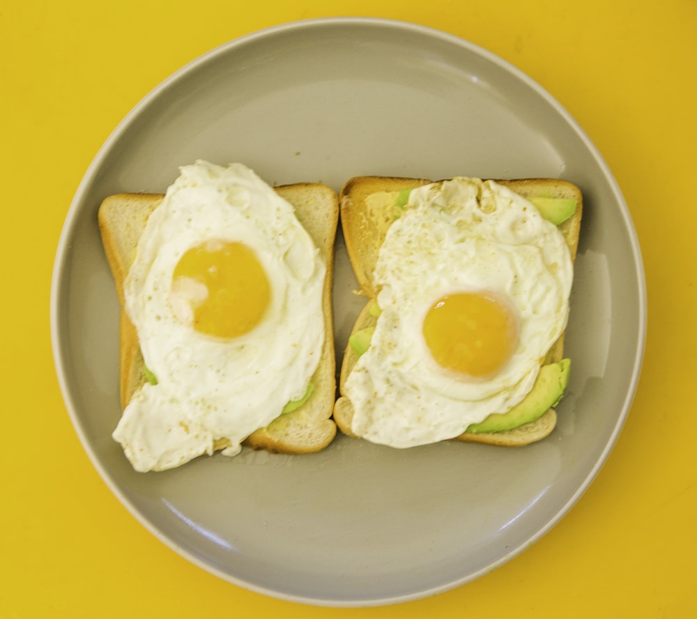 2 uova con il lato soleggiato rivolto verso l'alto su piatto di ceramica verde