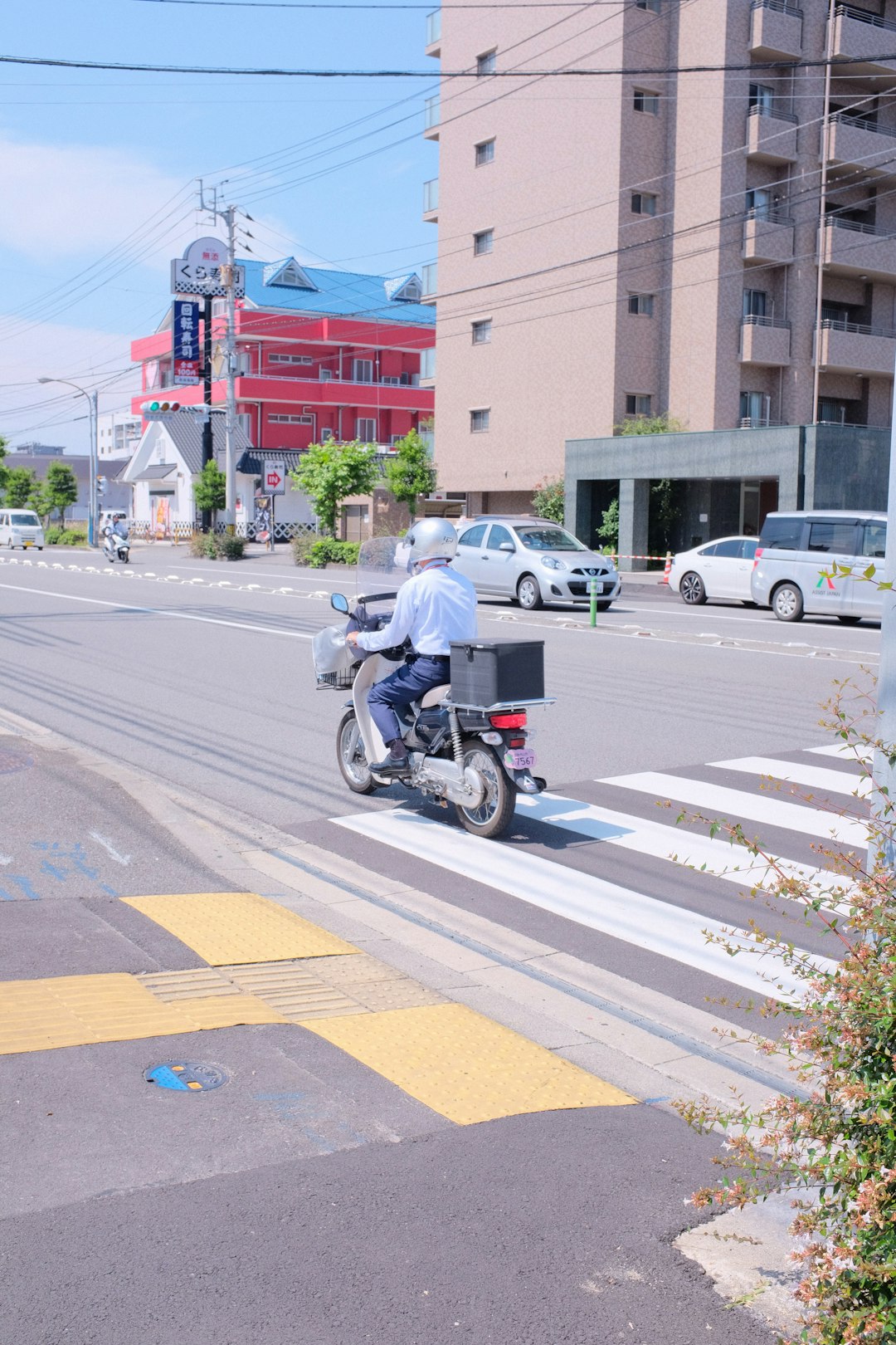 man in white shirt riding motorcycle on road during daytime