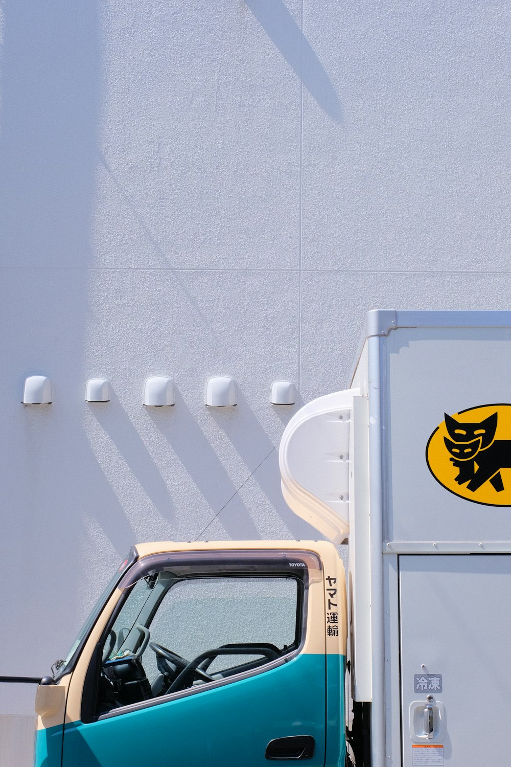 yellow and black car in front of white wall