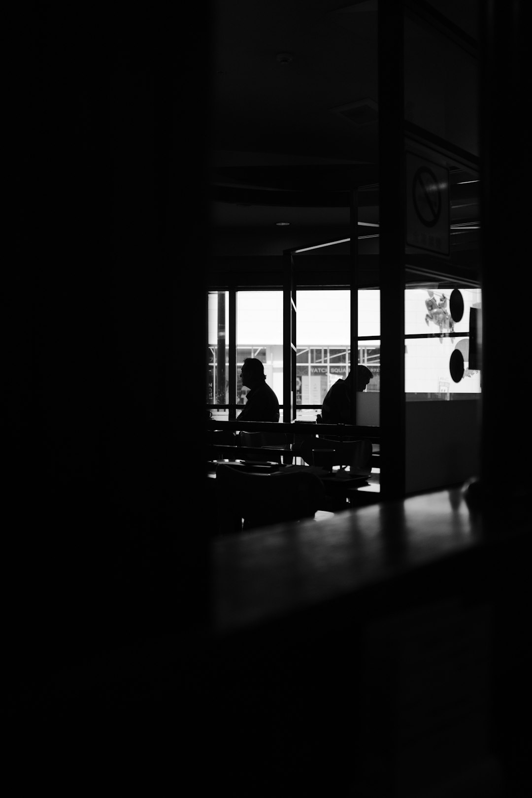 silhouette of people sitting on chair inside building