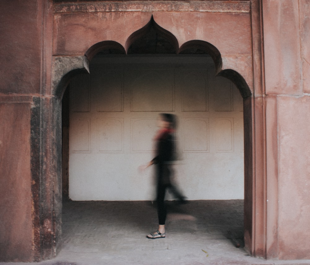 woman in black jacket walking on hallway