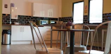 Cozy kitchen interior featuring white cabinets, a small island, and colorful backsplash tiles.