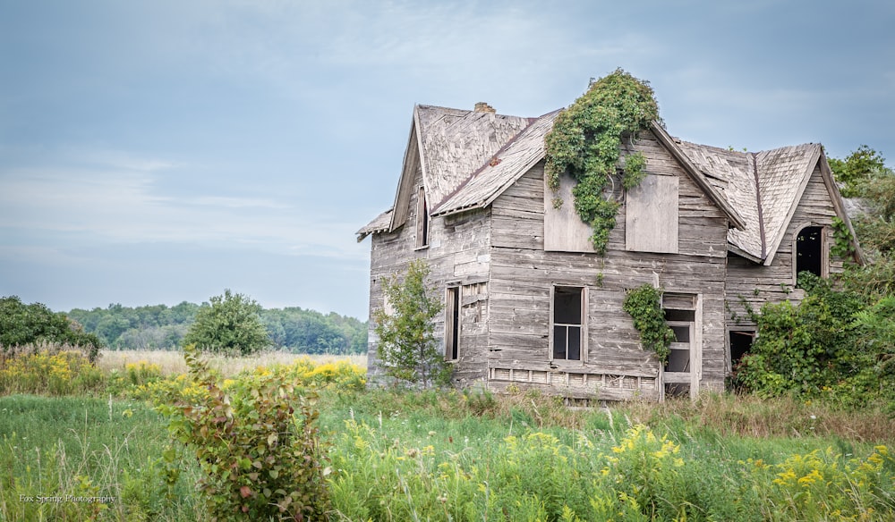 grey wooden house on green grass field during daytime