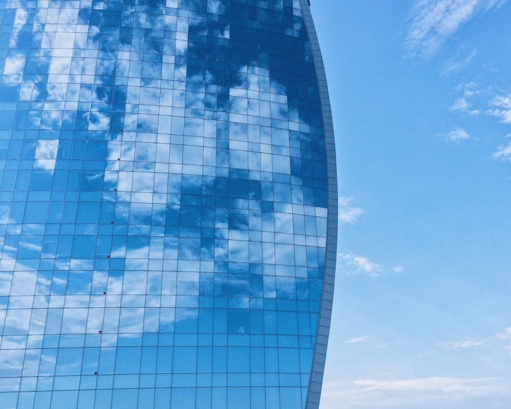 Bâtiment en verre bleu et blanc sous ciel bleu pendant la journée