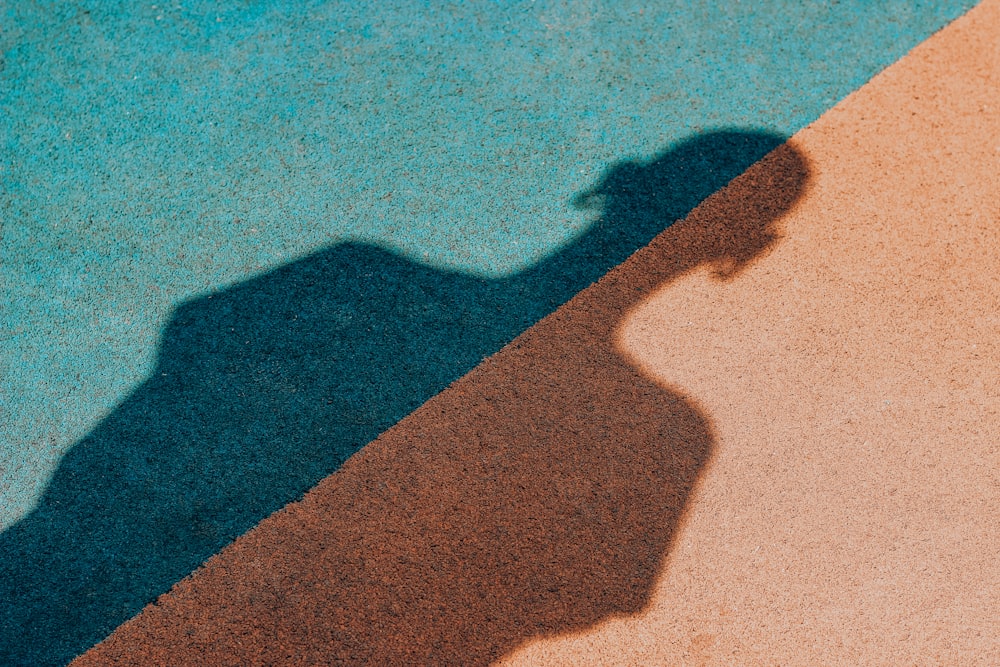 ombra di persona su sabbia marrone durante il giorno