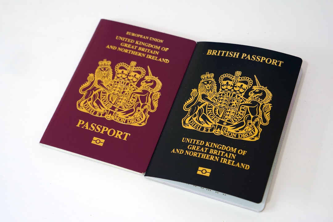red and gold book on white table, Old and new UK passport