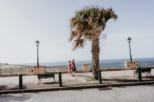 woman in red dress walking on brown wooden dock during daytime in San Juan United States