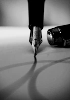 A craftsman delicately assembling a fountain pen nib with focused hands.