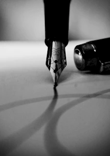 A craftsman delicately assembling a fountain pen nib with focused hands.