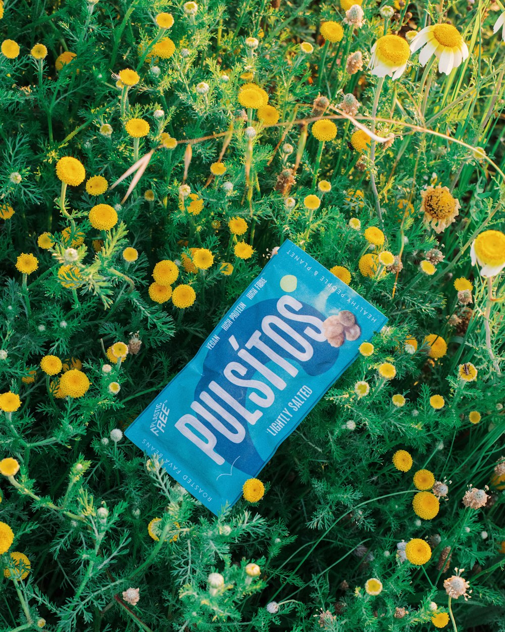 a book laying in the middle of a field of flowers