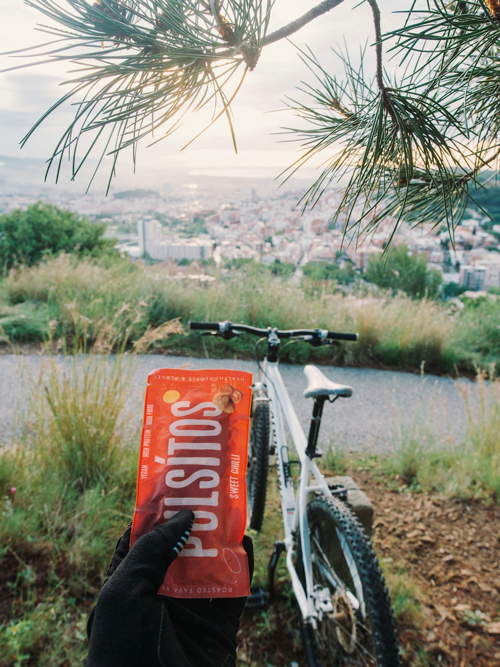 Bicicletta rossa e nera vicino al campo di erba verde durante il giorno