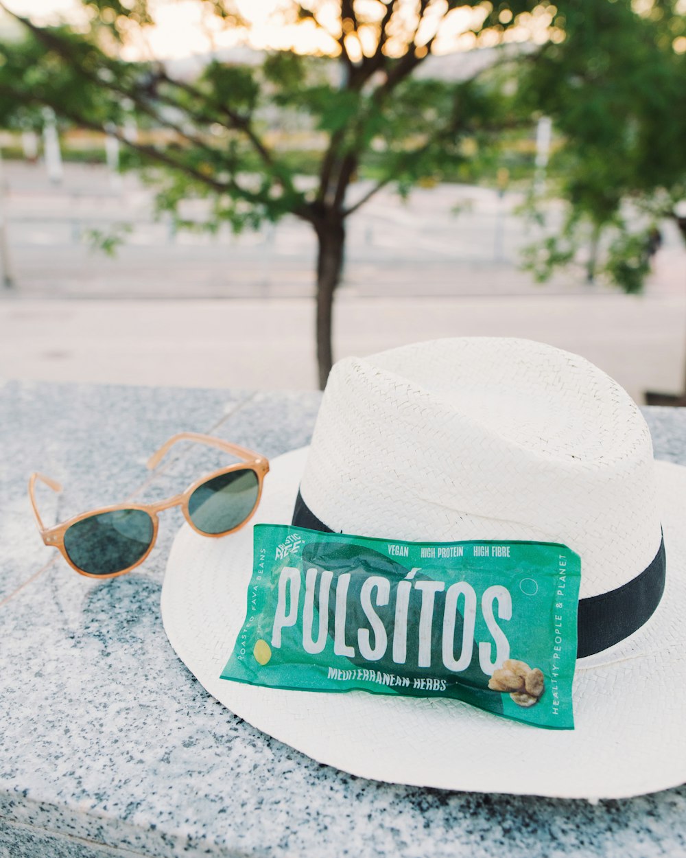 a hat, sunglasses, and a bar of pulsitos are sitting on