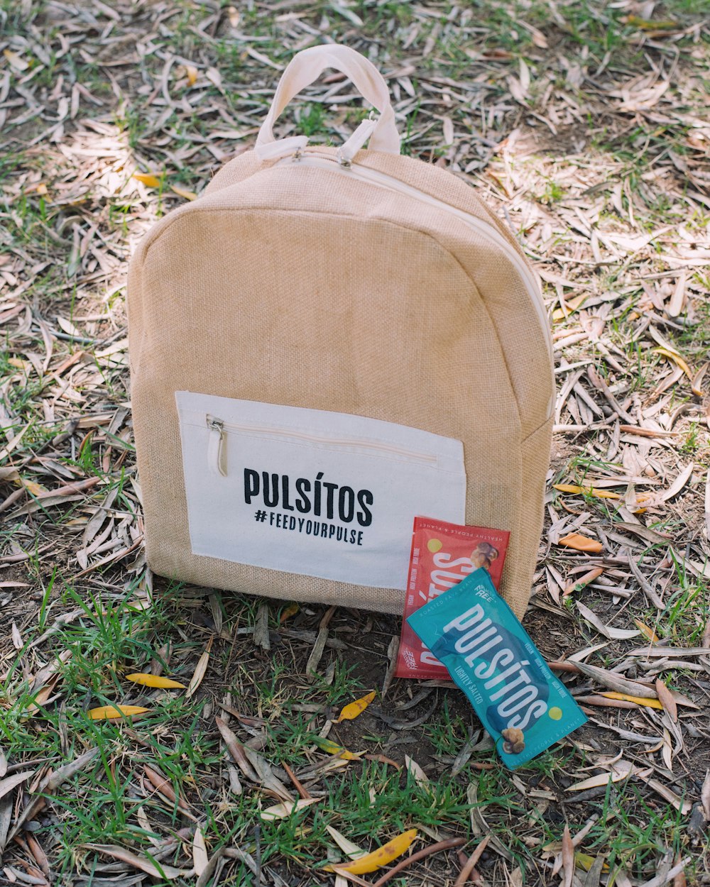 a brown bag sitting on top of a grass covered field