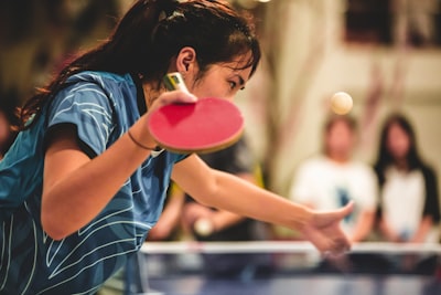 girl in blue and white striped shirt holding pink plastic cup table tennis zoom background