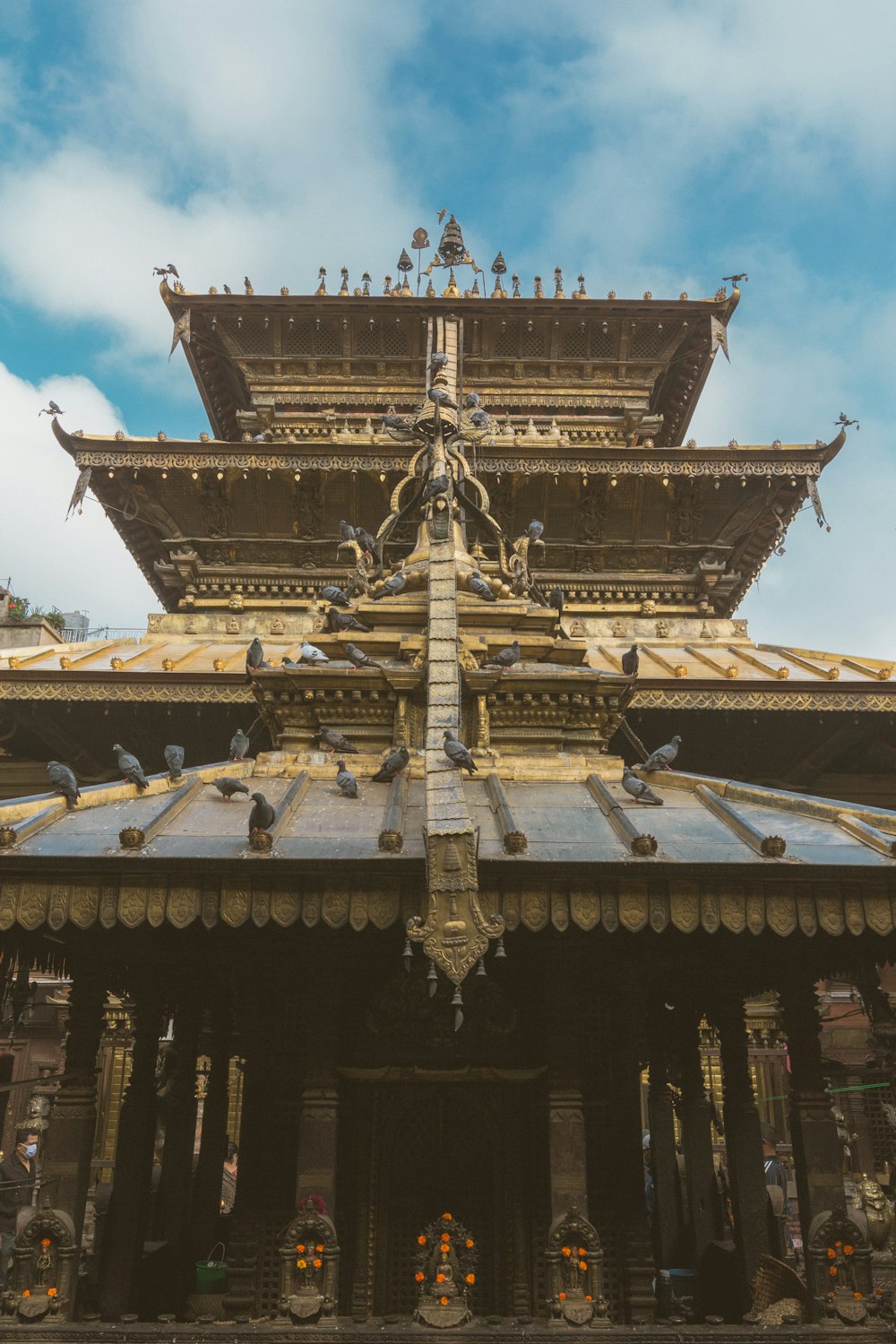 gold and white temple under white clouds during daytime