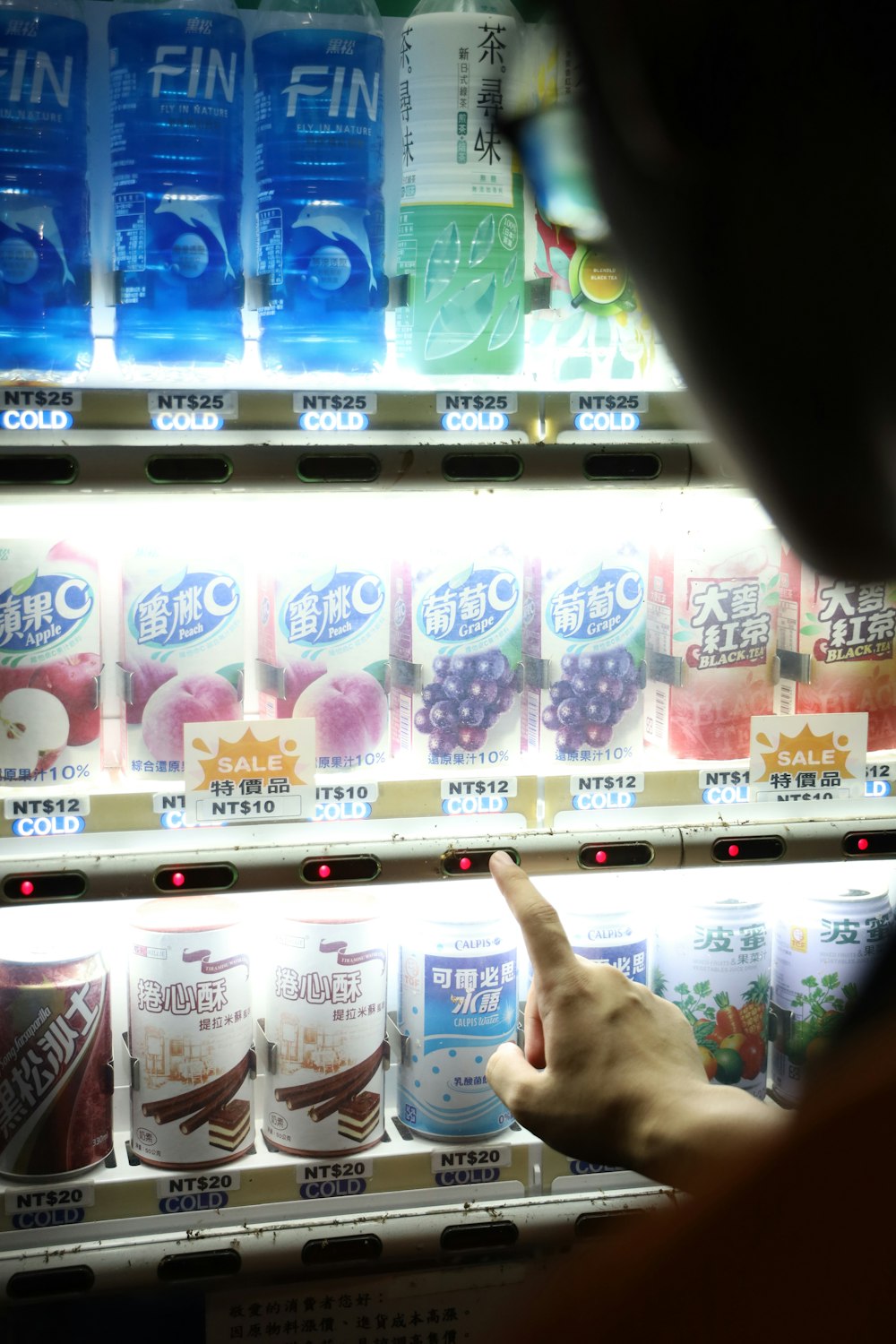 person pointing at the white and pink labeled bottle